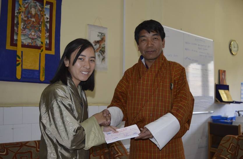 Ms. Tashi Dema, Assistant Research Officer, MoH, Thimphu Receiving the Research Grant from the Director, KGUMSB